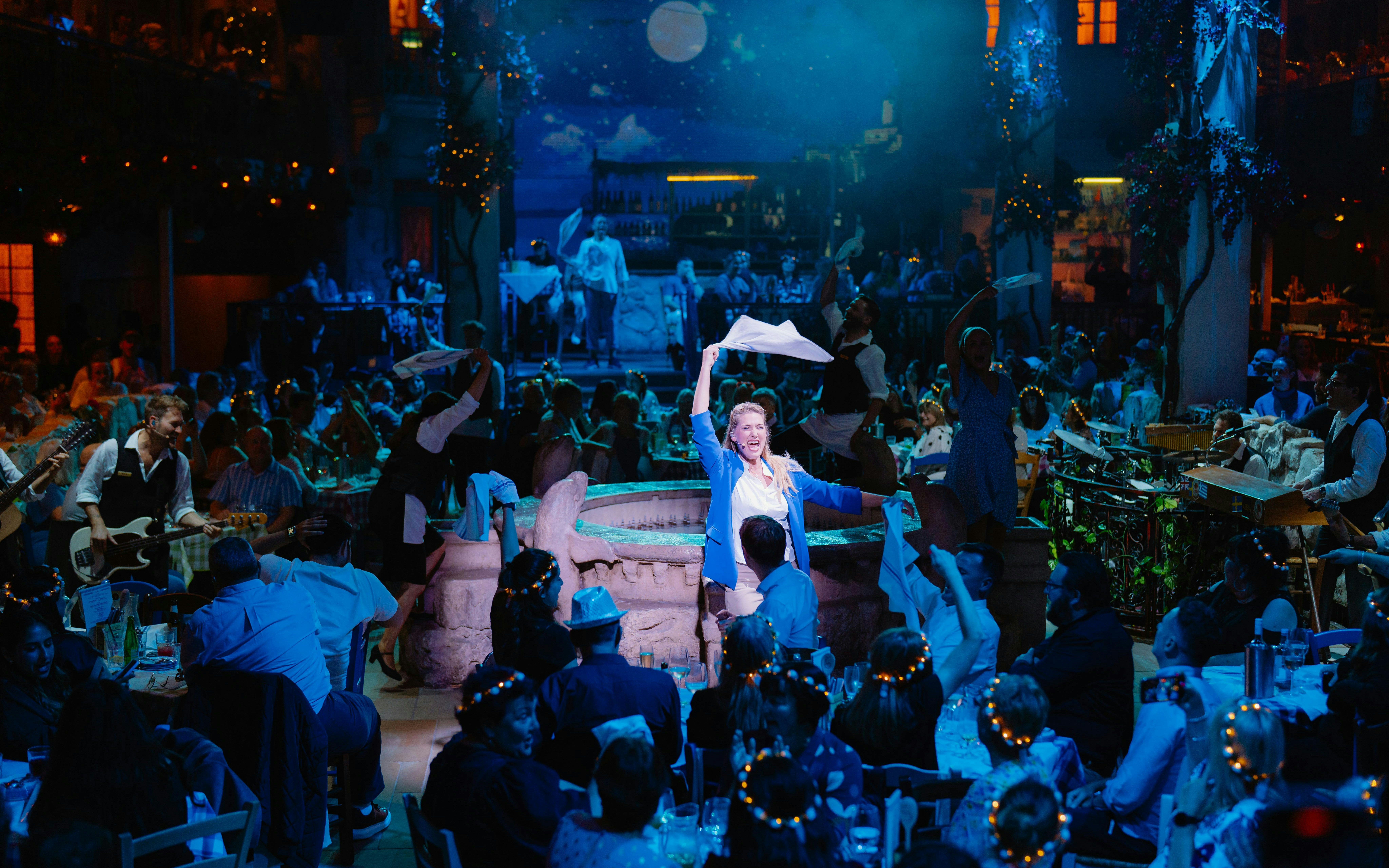 Mamma Mia! The Party performance with actors and audience in a lively dining setting.