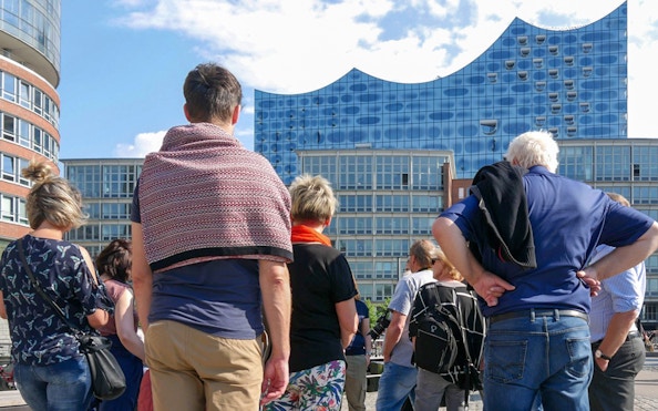Group of tourists on a guided tour in front of the Elbphilharmonie, Hamburg.