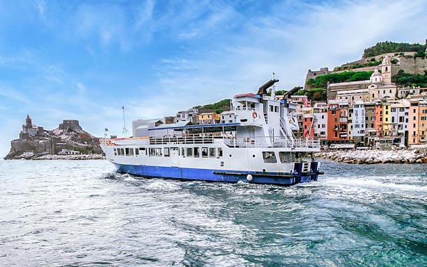 Ferry near colorful buildings and castle in La Spezia, Italy, en route to Cinque Terre.