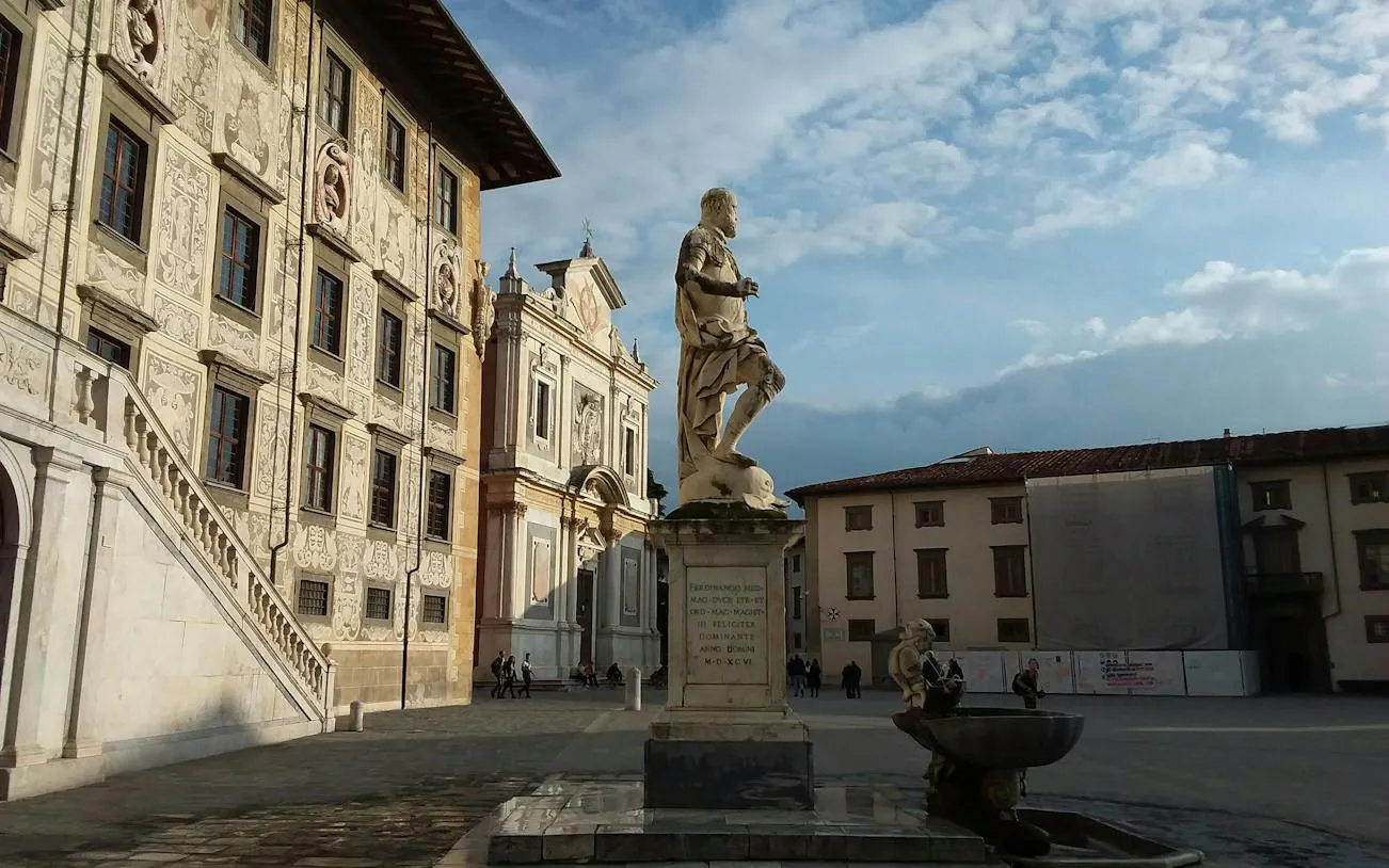 Statue in Knights' Square, Pisa, with historic buildings in the background.