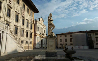Statue in Knights' Square, Pisa, with historic buildings in the background.