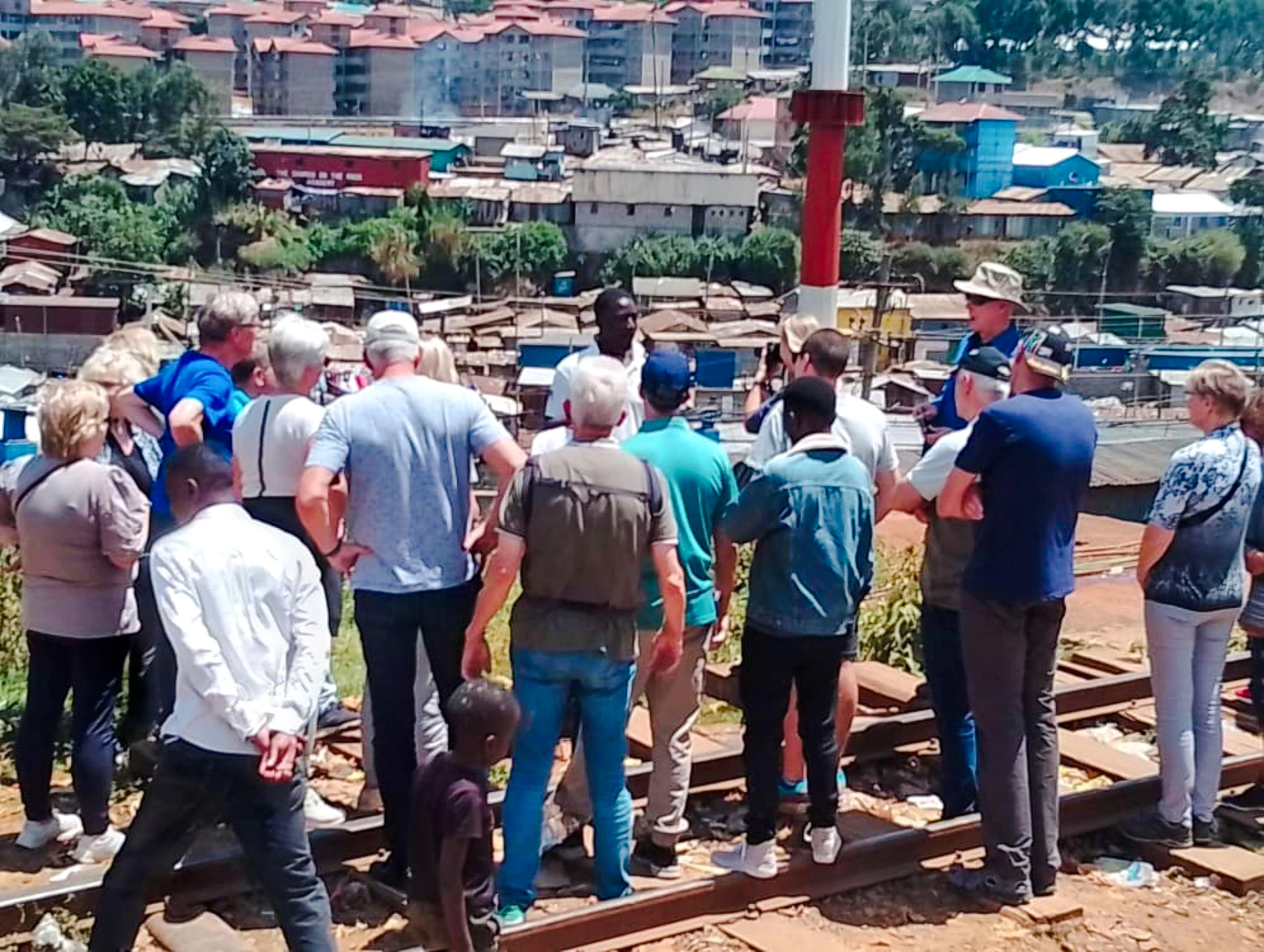 Tour group overlooking Kibera slum during guided walking tour in Nairobi.