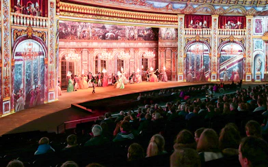 Stage performance at Puy du Fou France with historical costumes and elaborate set design.