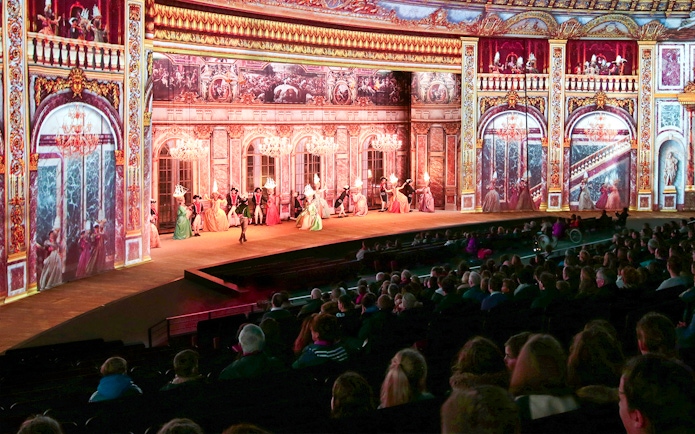 Stage performance at Puy du Fou France with historical costumes and elaborate set design.
