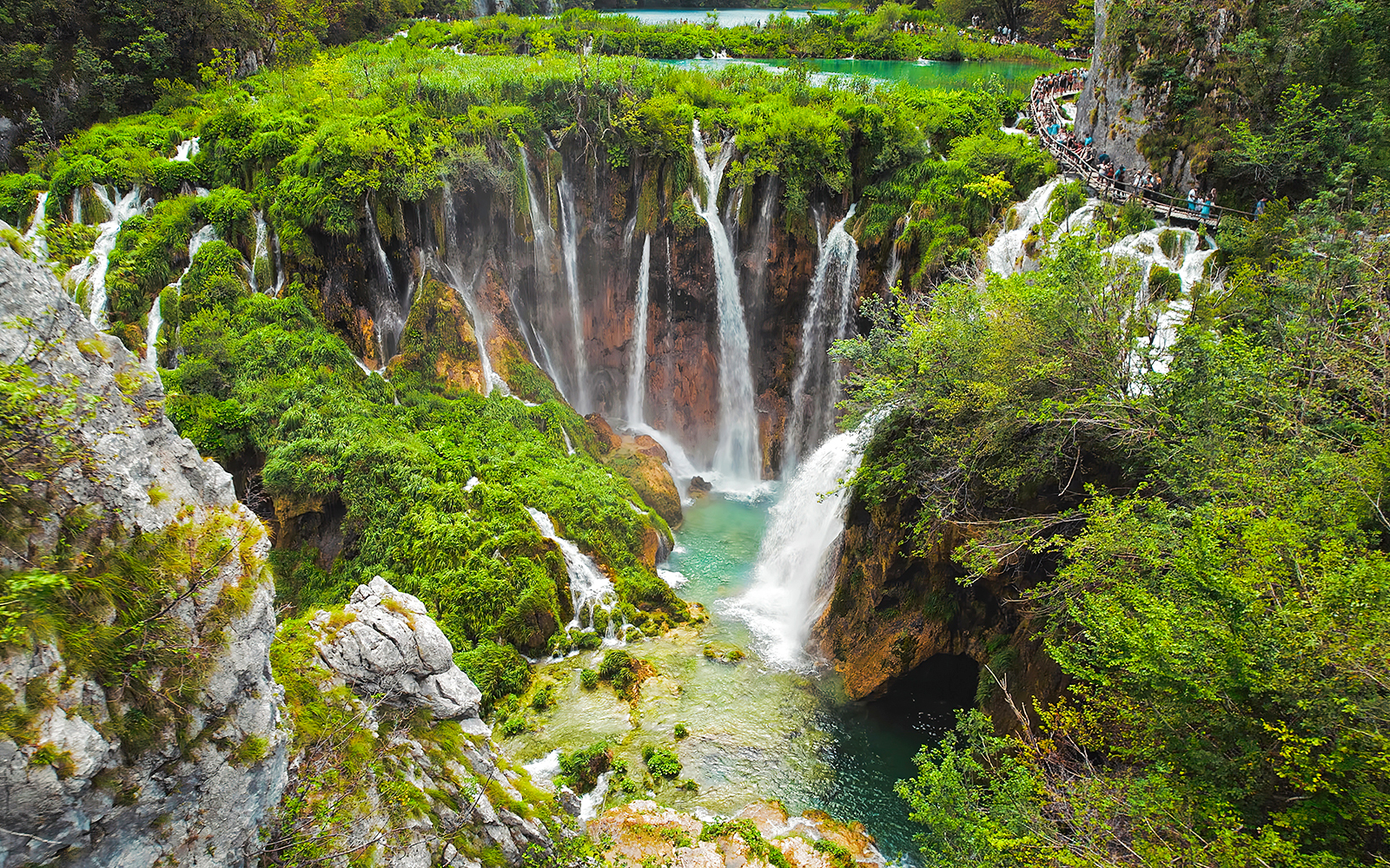 Waterfalls cascading into turquoise lakes at Plitvice Lakes National Park, Croatia.