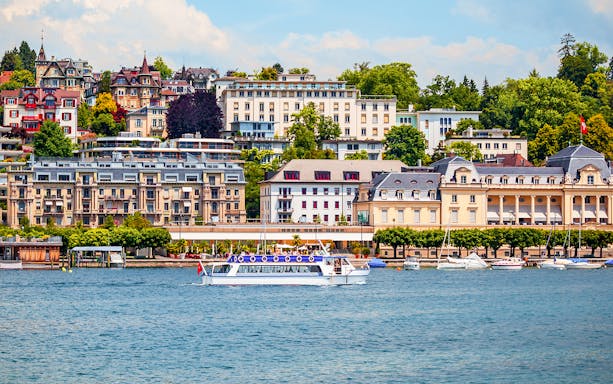 Zurich cityscape with a boat cruising on Lake Zurich.