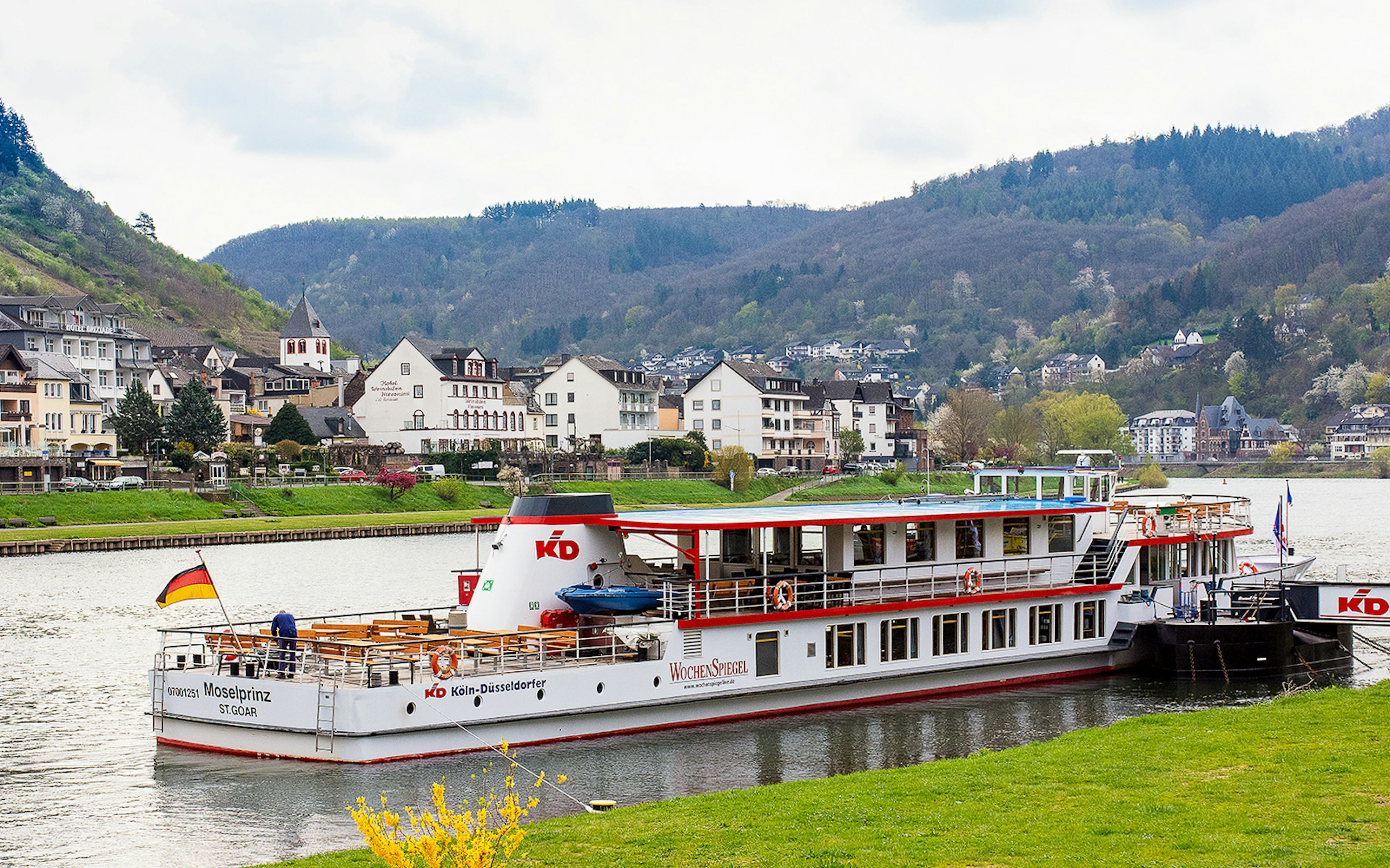 River cruise ship on the Moselle in Cochem with scenic town and hills in the background.