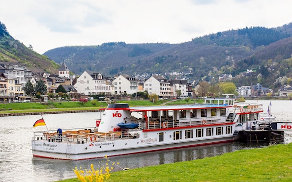 River cruise ship on the Moselle in Cochem with scenic town and hills in the background.