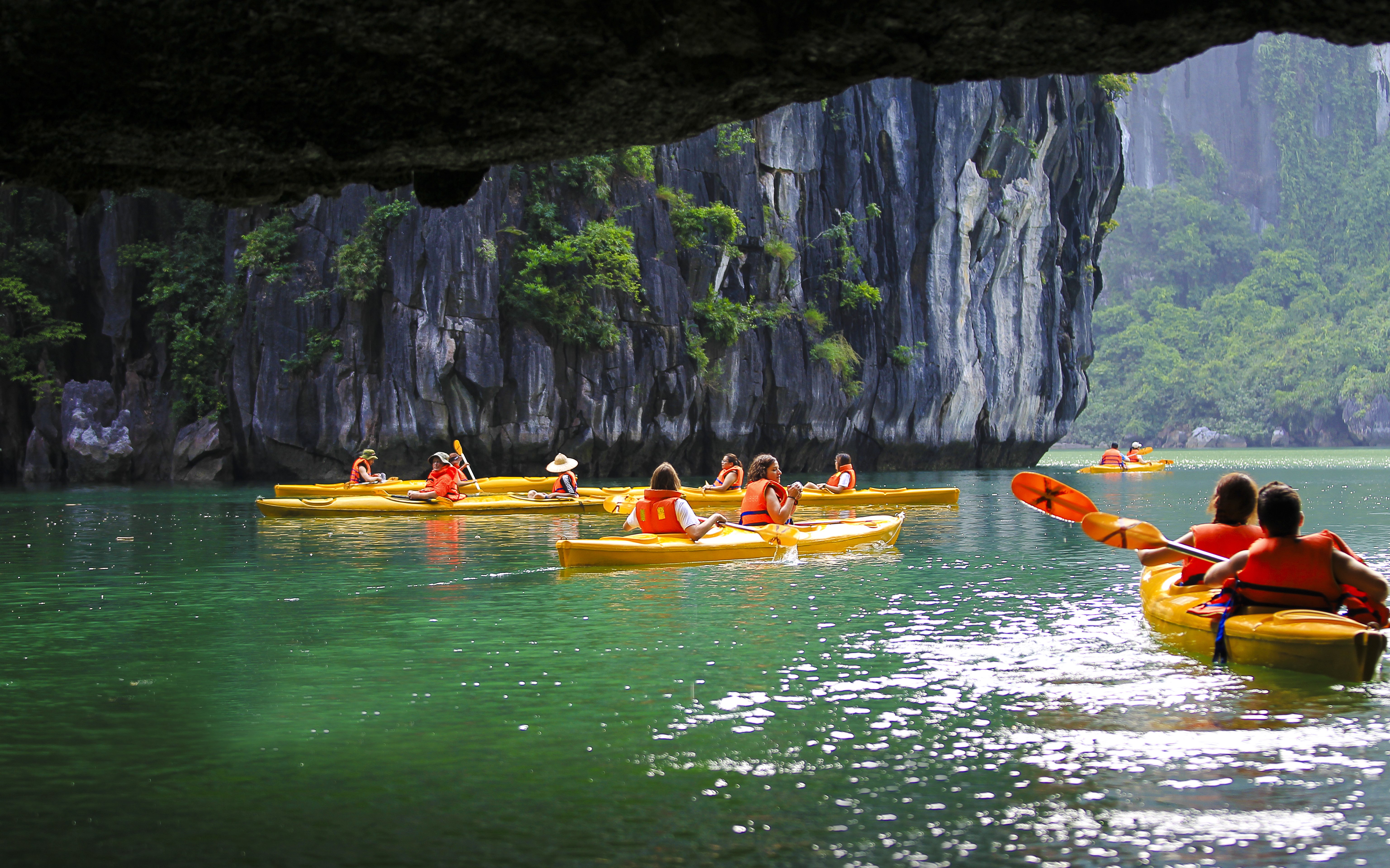 Kayakers exploring Luon Cave in Ha Long Bay, Vietnam.