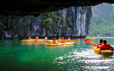 Kayakers exploring Luon Cave in Ha Long Bay, Vietnam.