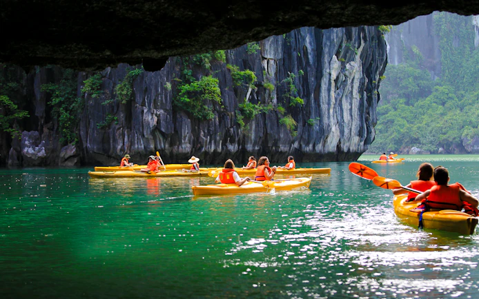 Kayakers exploring Luon Cave in Ha Long Bay, Vietnam.