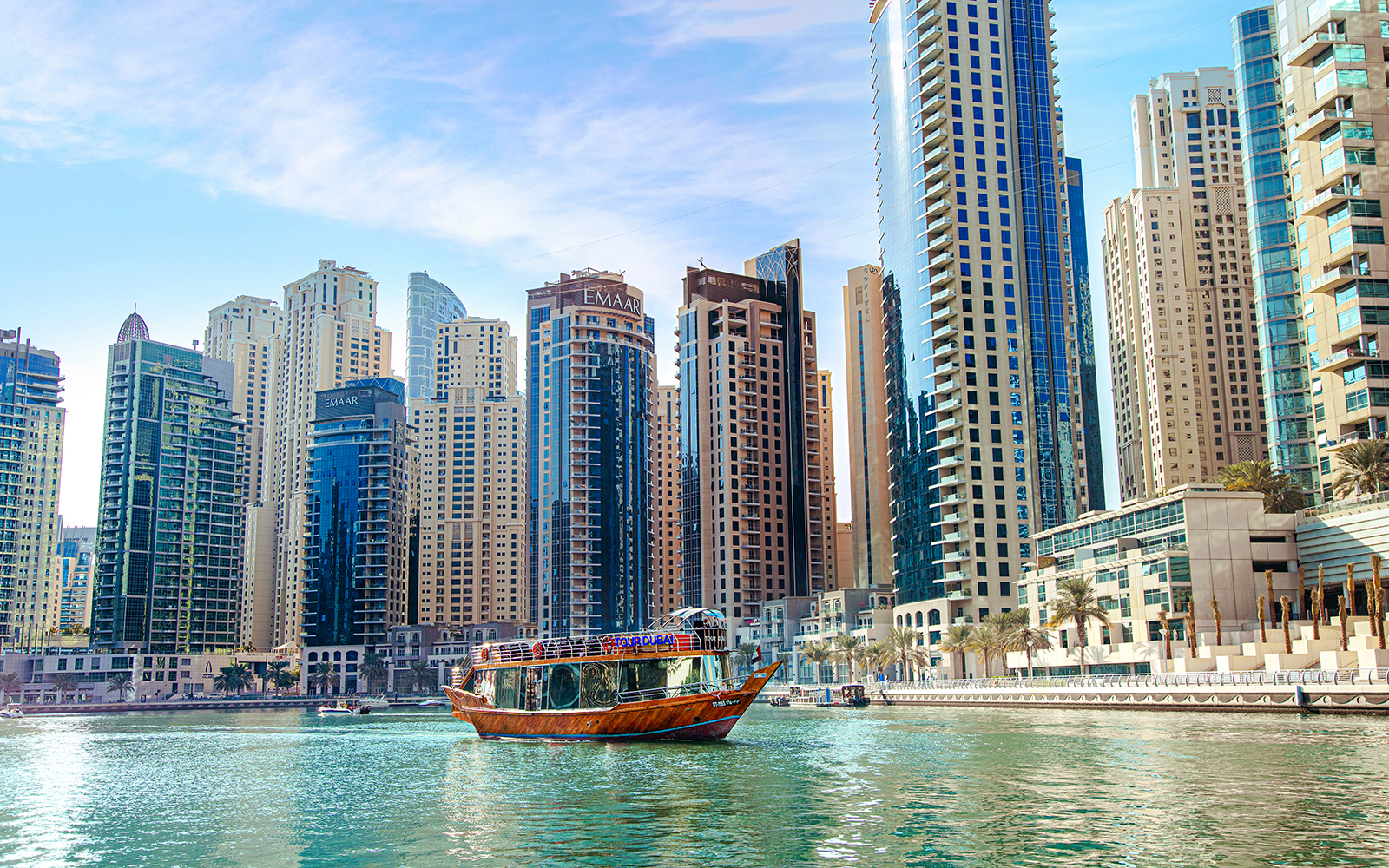 Dhow cruise on Dubai Creek with city skyline in the background.