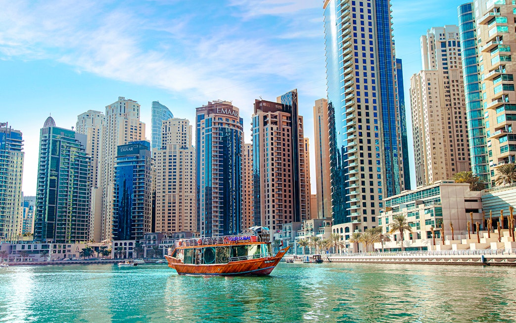 Dhow cruise on Dubai Creek with city skyline in the background.