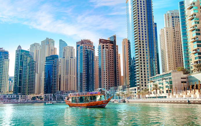 Dhow cruise on Dubai Creek with city skyline in the background.