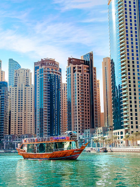 Dhow cruise on Dubai Creek with city skyline in the background.