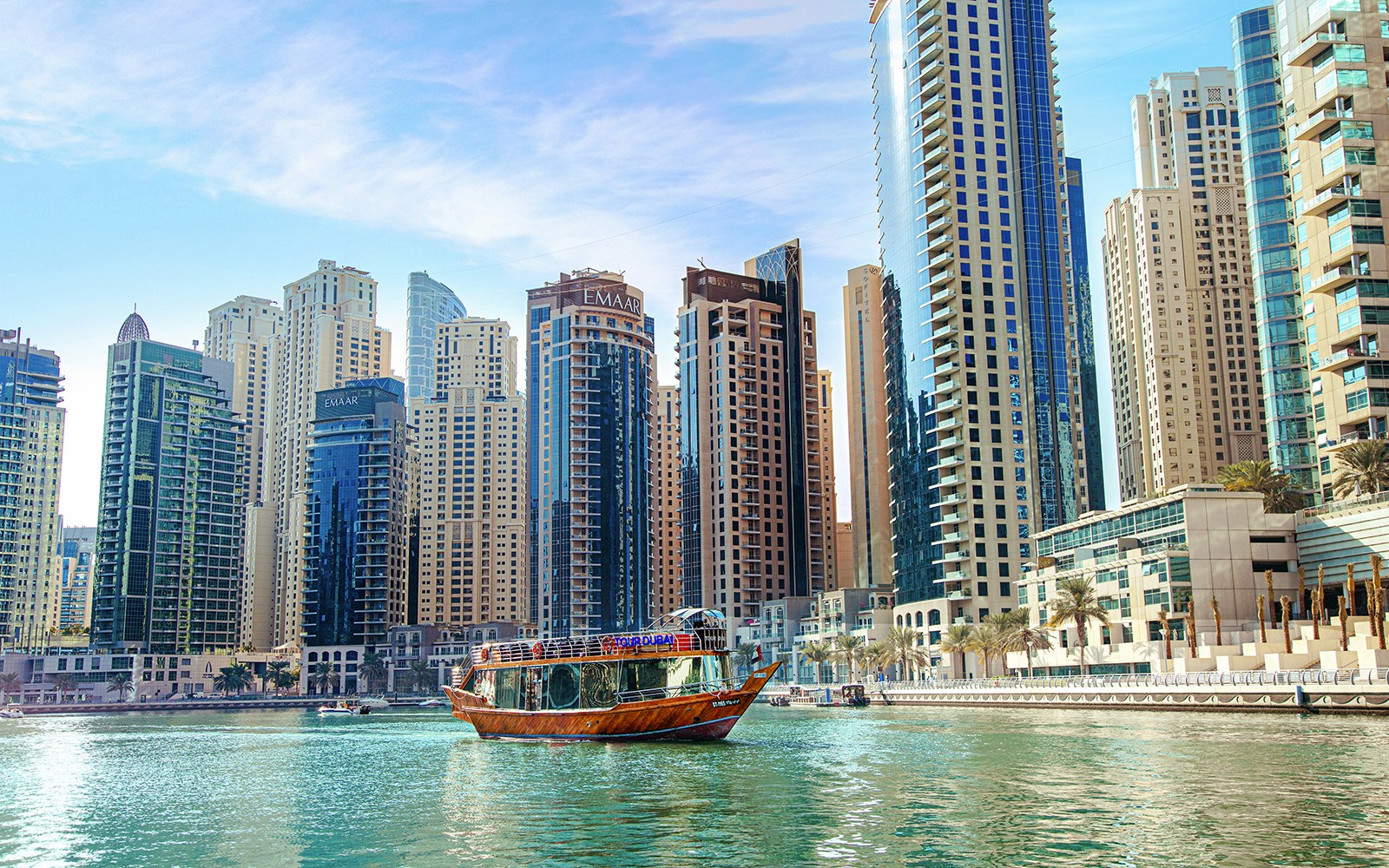 Dhow cruise on Dubai Creek with city skyline in the background.
