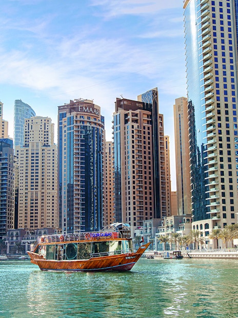 Dhow cruise on Dubai Creek with city skyline in the background.