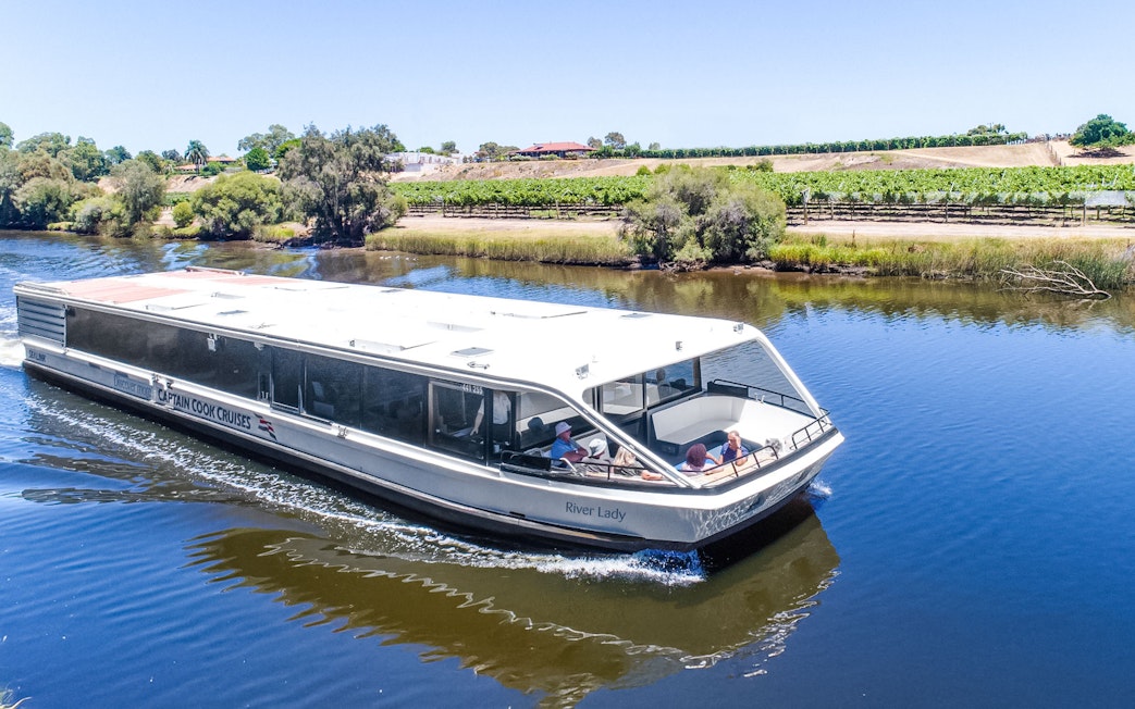 Cruise boat on Swan River with vineyards in Swan Valley, Australia.