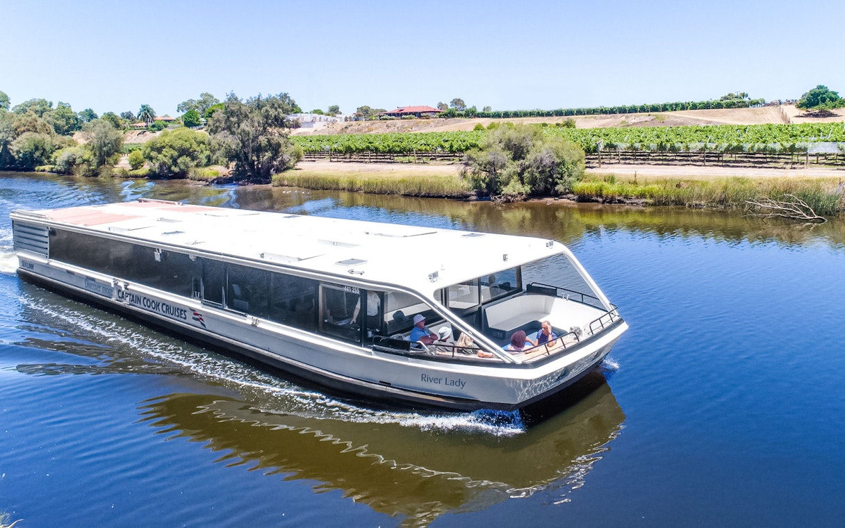 Cruise boat on Swan River with vineyards in Swan Valley, Australia.