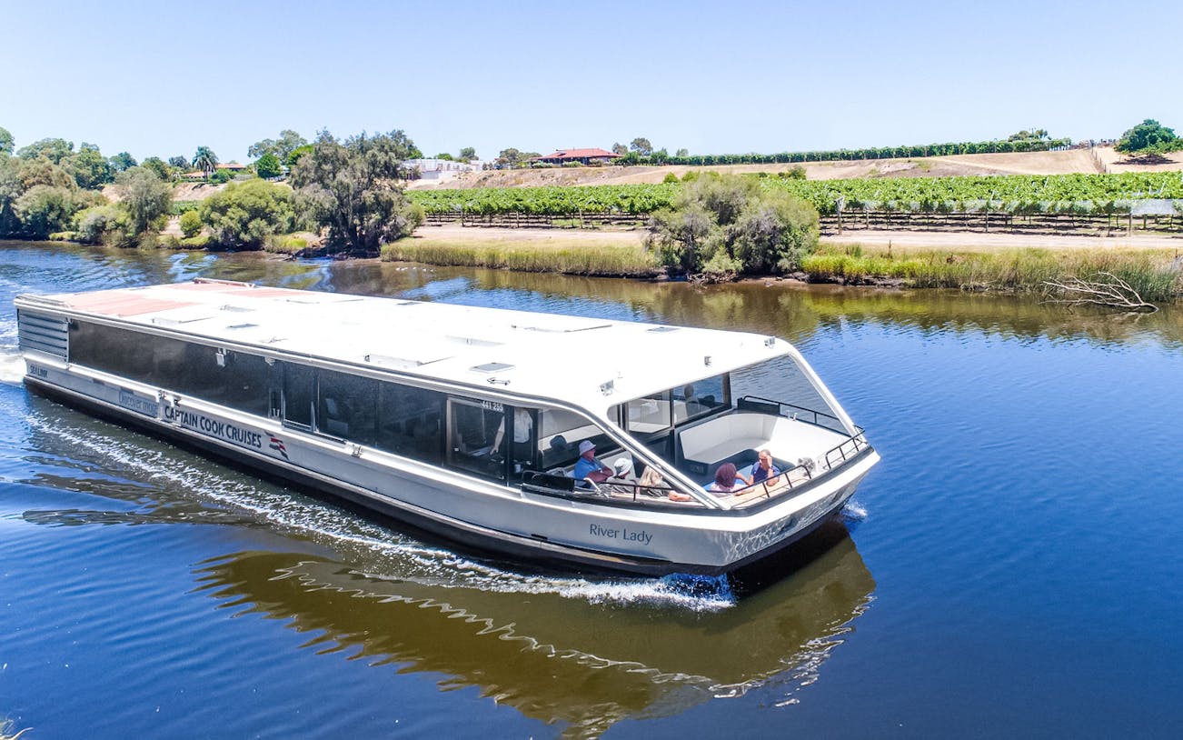 Cruise boat on Swan River with vineyards in Swan Valley, Australia.