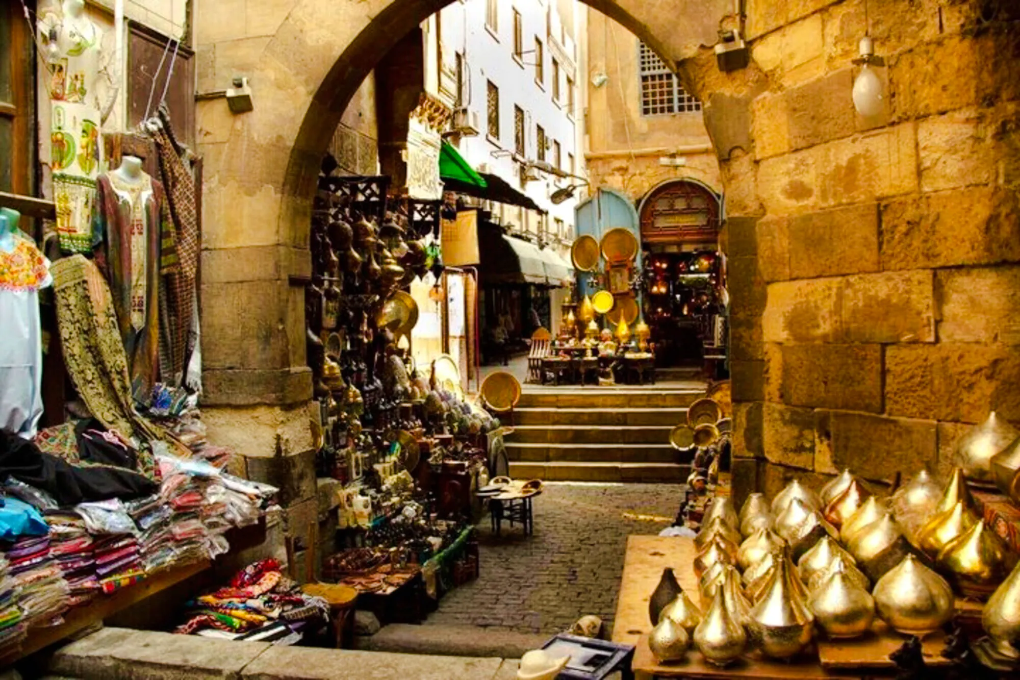 Khan el-Khalili market alley with shops displaying textiles and brassware, Cairo.