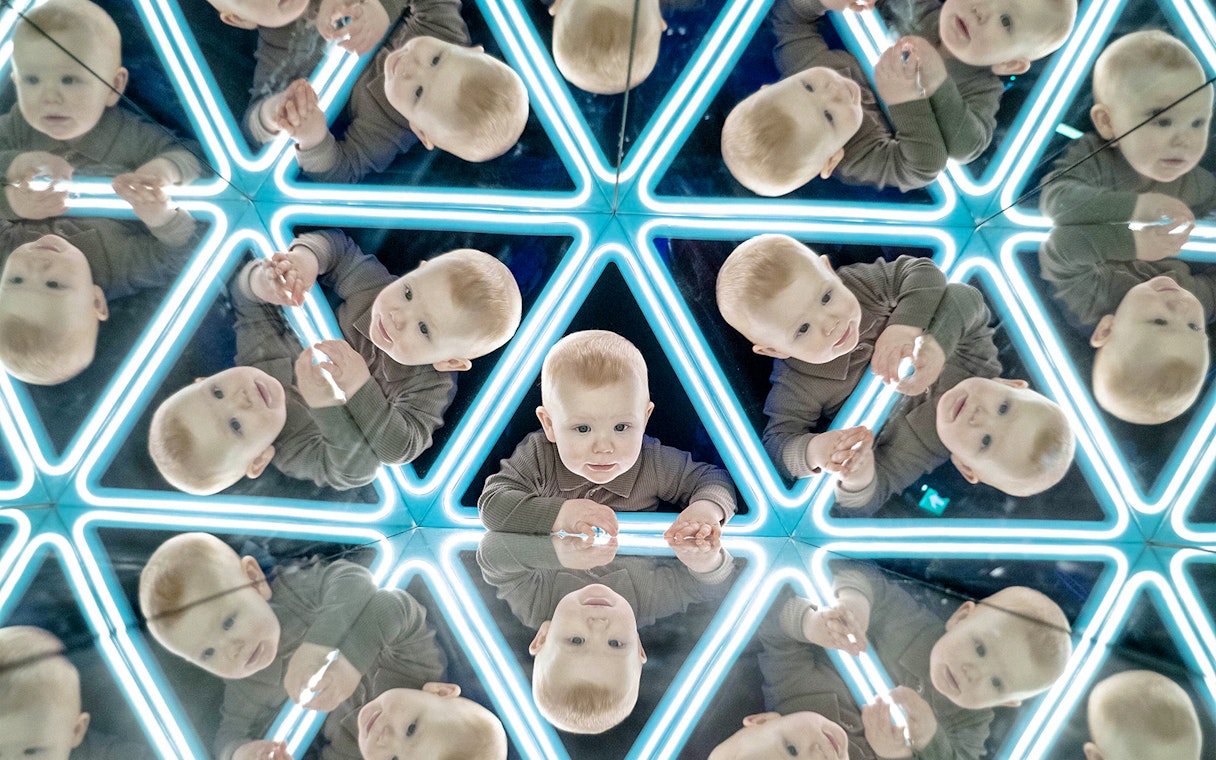 Child exploring mirrored exhibit at the World of Illusions.