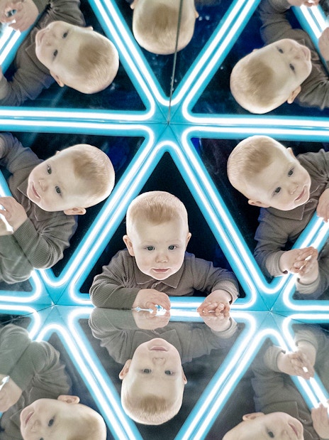 Child exploring mirrored exhibit at the World of Illusions.