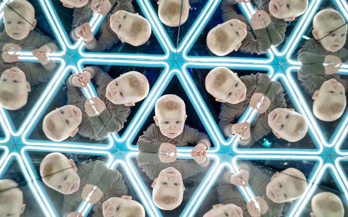 Child exploring mirrored exhibit at the World of Illusions.