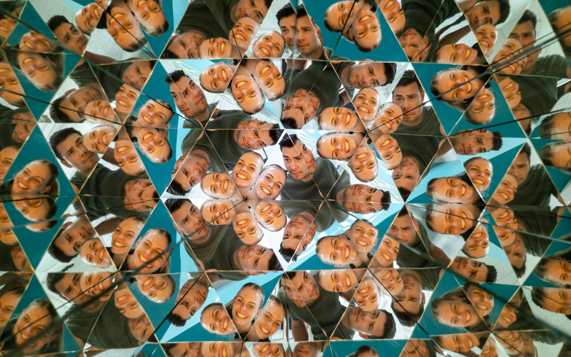 Visitors reflected in kaleidoscope mirrors at Museum of Illusions Amsterdam.