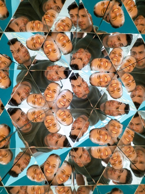 Visitors reflected in kaleidoscope mirrors at Museum of Illusions Amsterdam.