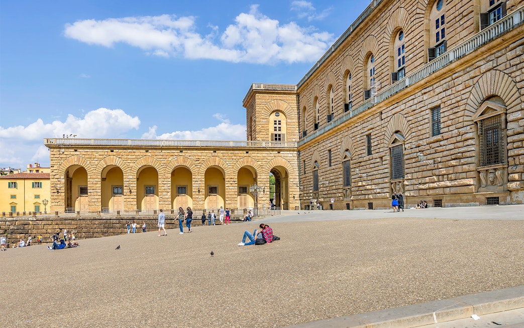Visitors relaxing outside Palazzo Pitti in Florence, Italy.