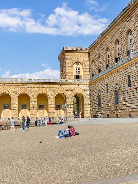 Visitors relaxing outside Palazzo Pitti in Florence, Italy.