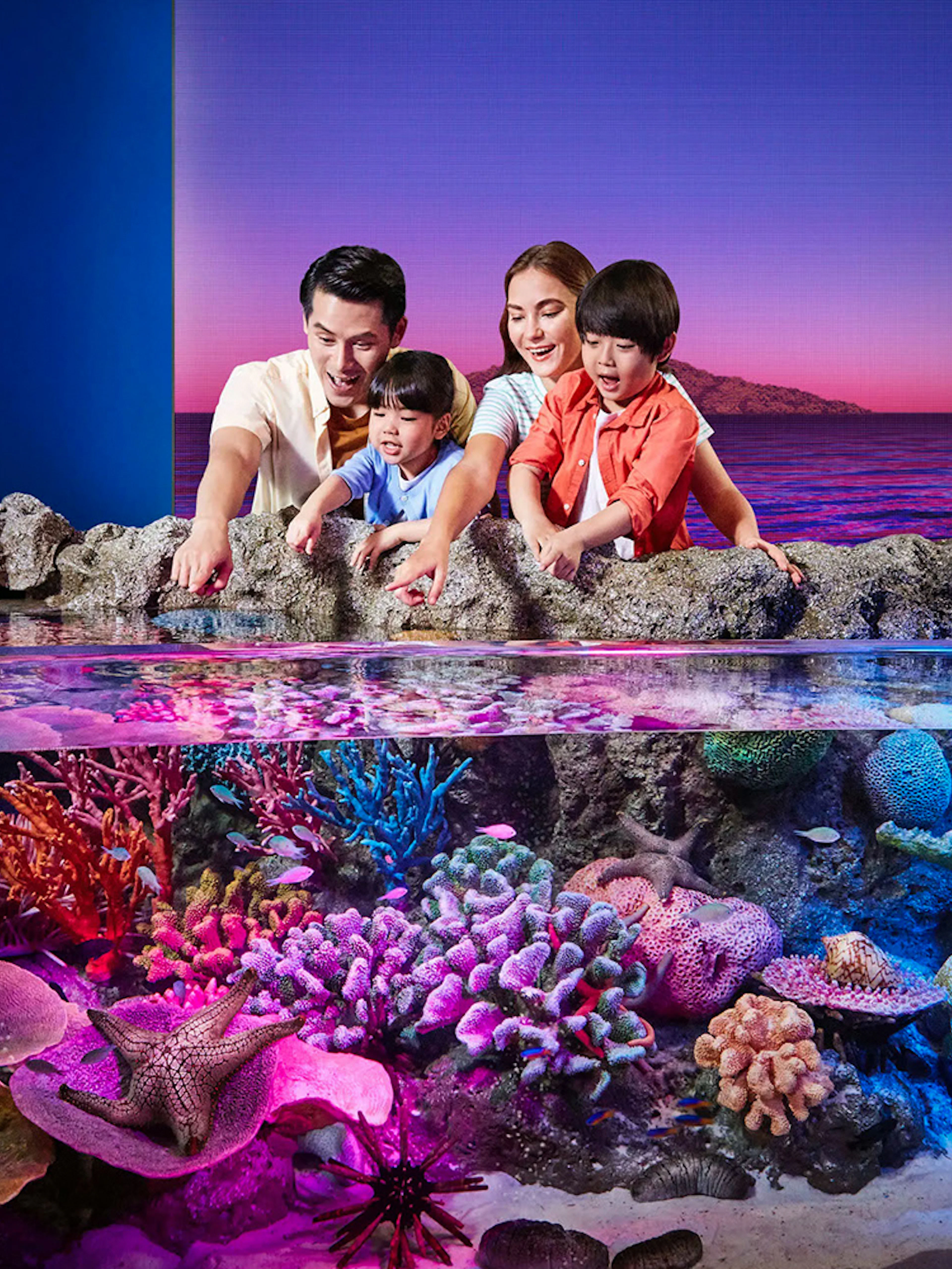 Tourists exploring vibrant rock pools at Sea Life Bangkok.