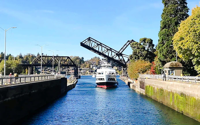 Boat passing through a raised drawbridge on a harbor cruise.