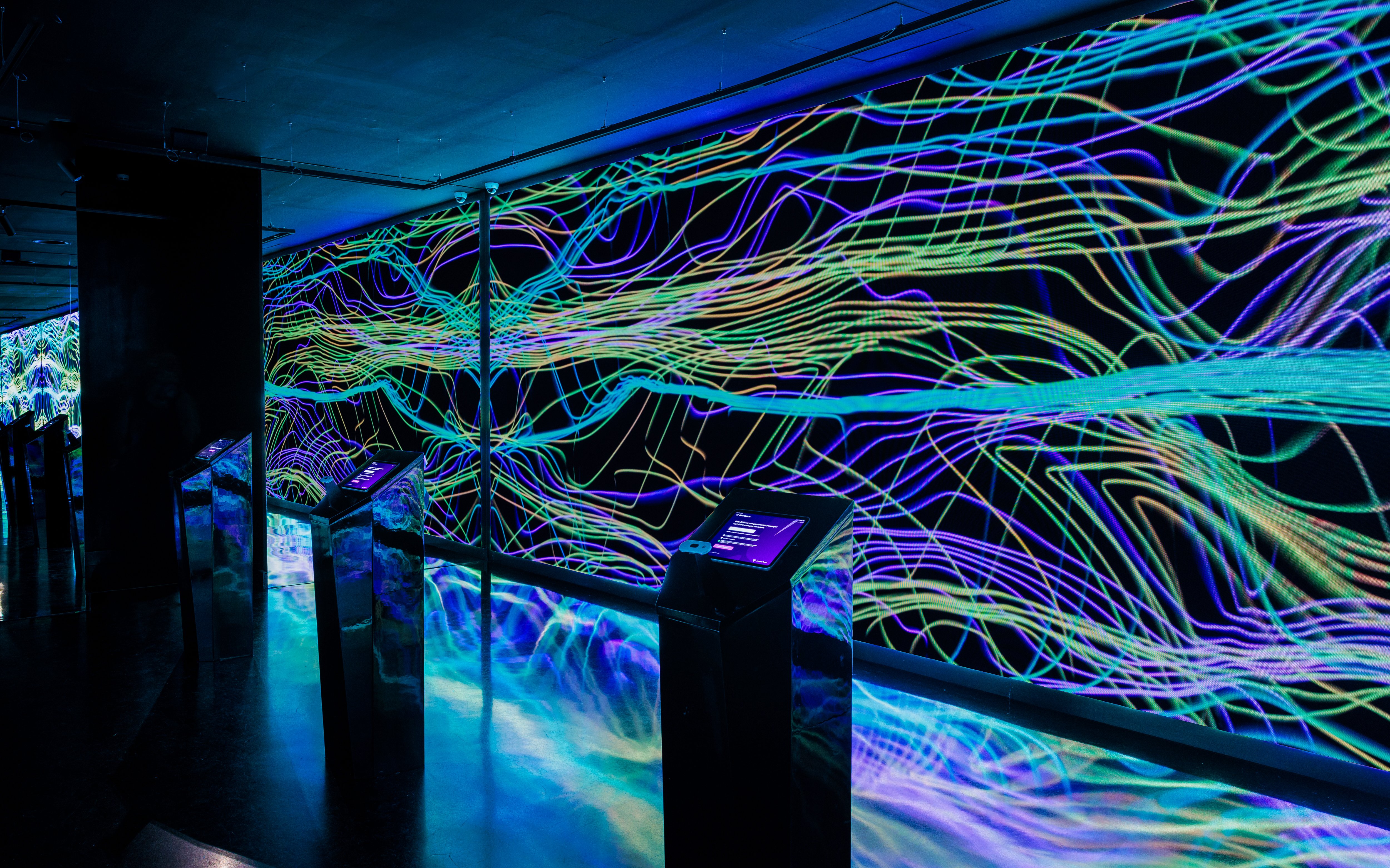 Interactive digital art installation at Moco Museum Barcelona with vibrant neon lines.