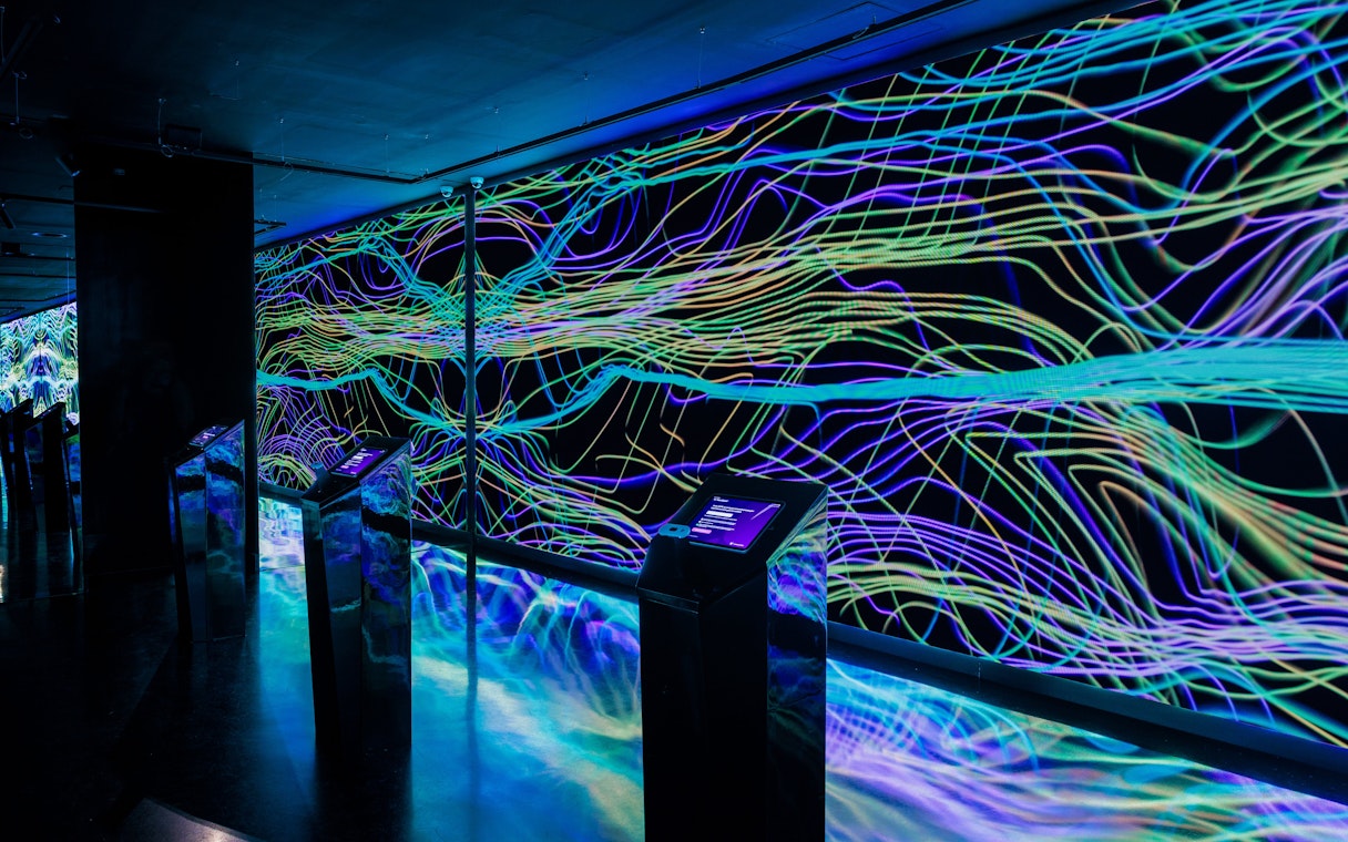 Interactive digital art installation at Moco Museum Barcelona with vibrant neon lines.