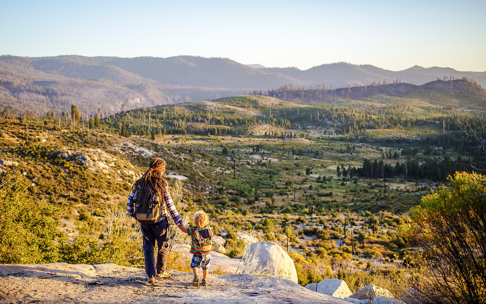 Mother and son overlooking Yosemite National Park landscape.
