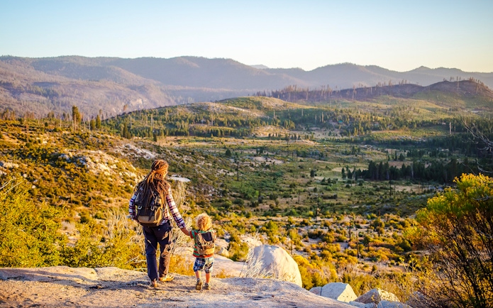 Mother and son overlooking Yosemite National Park landscape.