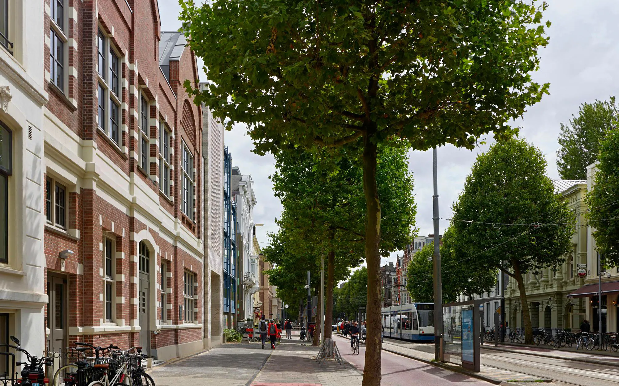 Street view near the National Holocaust Museum in Amsterdam with bicycles and tram tracks.