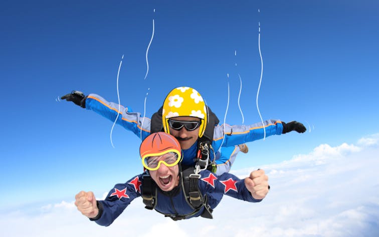 Tandem skydiving over clouds, adventure seekers in freefall.