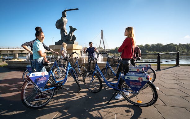 Cyclists gather near the Warsaw Mermaid statue during a 3-hour bike tour.