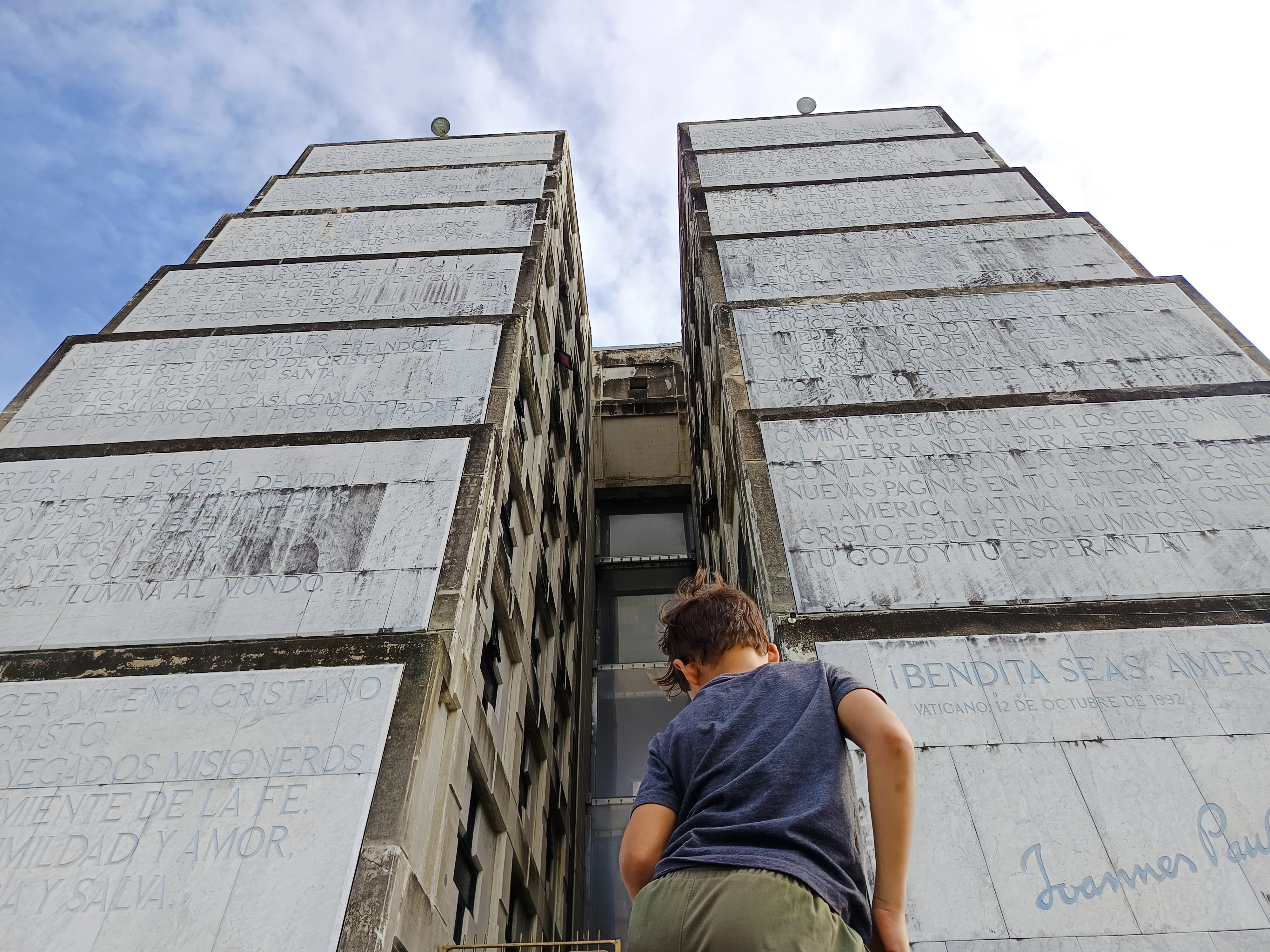 Child looking up at Columbus Lighthouse monument in Santo Domingo during a city tour.