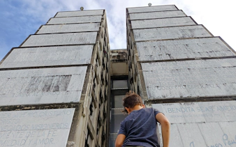 Child looking up at Columbus Lighthouse monument in Santo Domingo during a city tour.