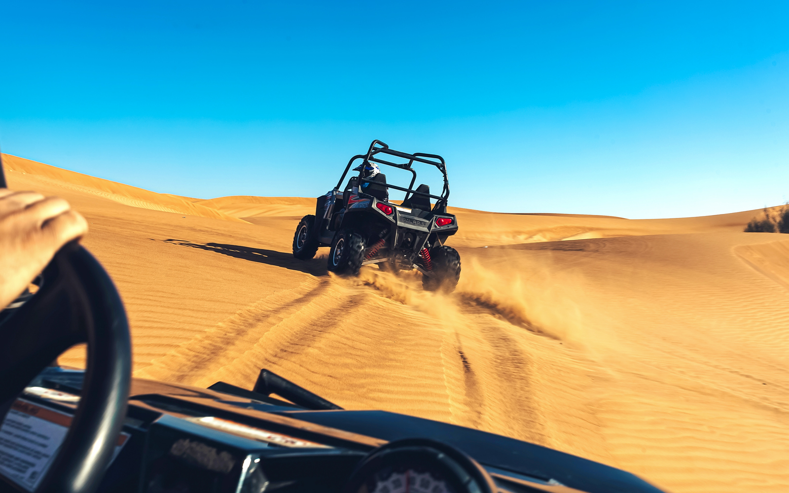 Quad biking adventure on desert dunes during a tour with hotel transfers and breakfast.