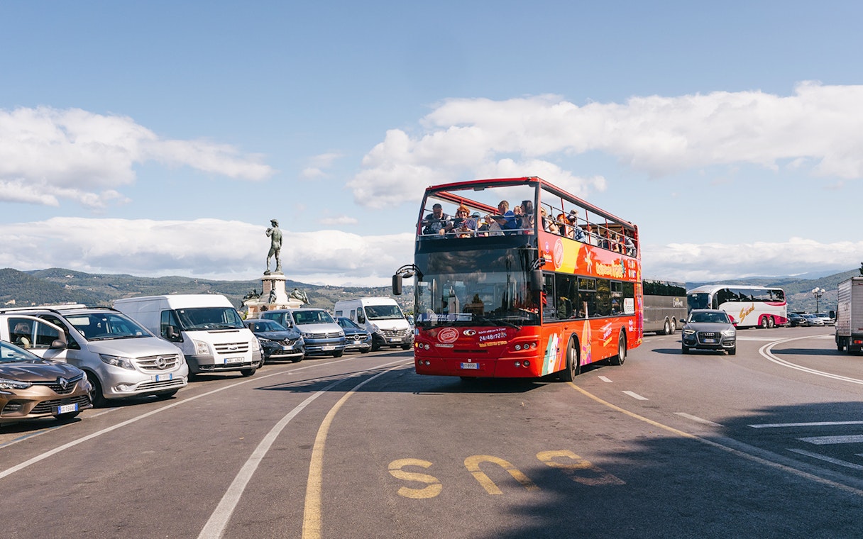Open-top red bus on Florence Hop-On Hop-Off tour near Piazzale Michelangelo.
