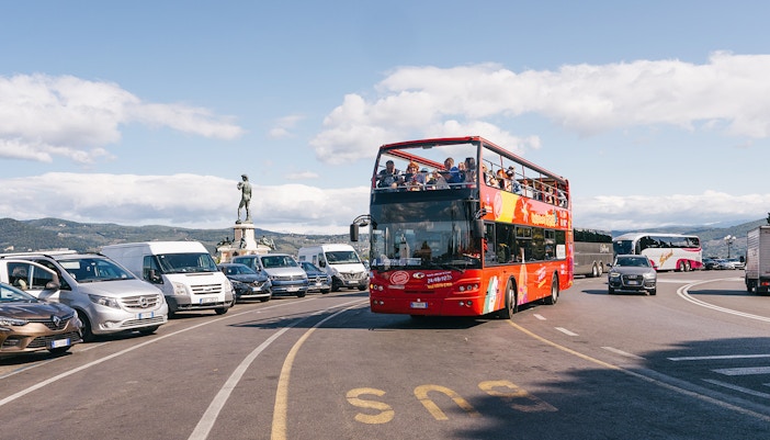 Tourists enjoying the City Sightseeing 24/48/72-Hr Hop-On Hop-Off Tour of Florence, Italy, with a view of the iconic Florence Cathedral from the open-top bus