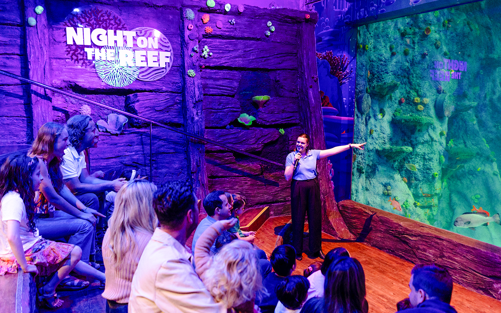 Guide speaking to visitors at SEA LIFE Melbourne's Night on the Reef exhibit.