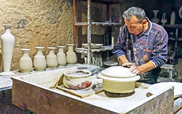 Potter crafting ceramics in Cappadocia workshop during 2-day private guided tour.