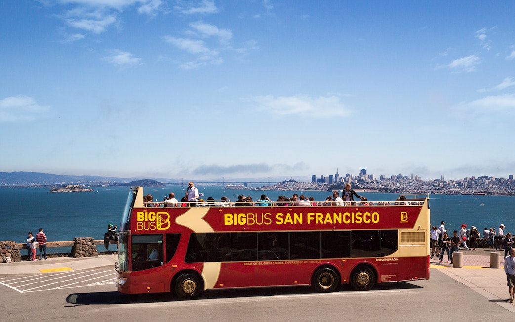 Big Bus San Francisco at viewpoint with city skyline and bay in background.