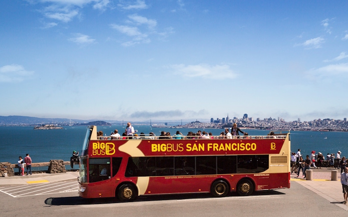 Big Bus San Francisco at viewpoint with city skyline and bay in background.